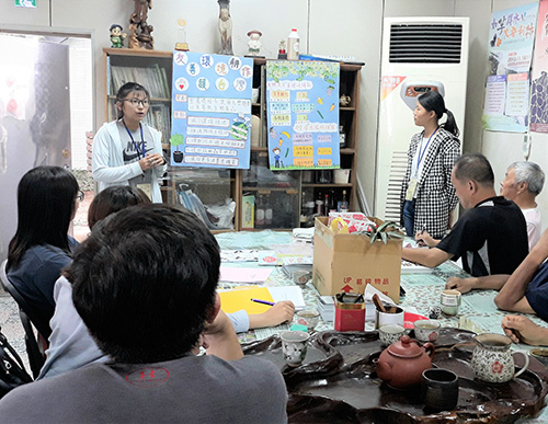 吳姿儀(左前1）、江翊瑄同學(右前1)自製海報向社區居民推廣友善環境耕作
