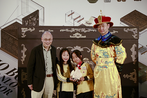 故宮院長吳密察(左1)與魔術師黃柏翰(右1)致贈天機哥給學童